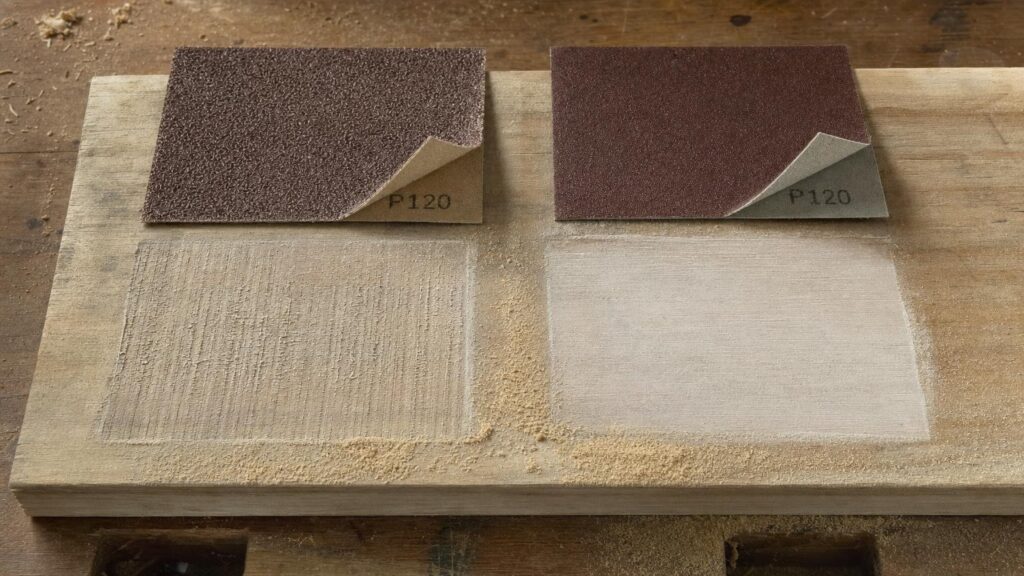 Two P120 abrasive samples with different coatings and backings beside wood test strips showing different scratch patterns.